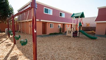 Hillsboro apartment for rent - a playground in front of a house with a swing set
