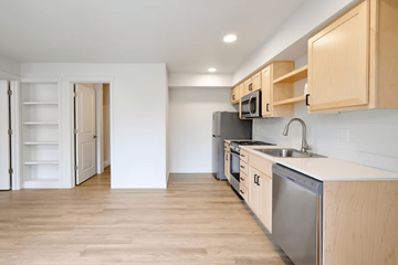 Portland apartment for rent - A kitchen with wooden cabinets and a stainless steel dishwasher.
