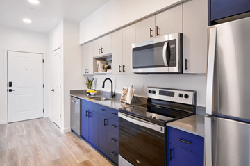 Portland apartment for rent - A modern kitchen with blue cabinets and stainless steel appliances.