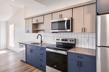 Portland apartment for rent - A kitchen with a black stove top oven and a black microwave above a sink.