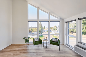 Portland apartment for rent - A room with a green chair and a table with a potted plant on it.