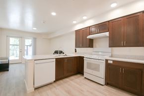 Boise apartment for rent - a large kitchen with white appliances and wooden cabinets