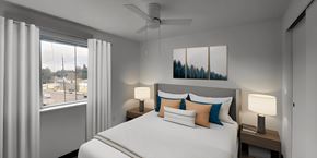 Portland apartment for rent - a bedroom with a large bed and a ceiling fan