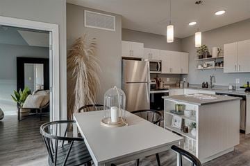 Saskatoon townhouse for rent - an open kitchen and dining room with a white table and chairs
