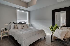 Saskatoon townhouse for rent - a bedroom with a bed and a large mirror