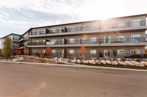 Saskatoon apartment for rent - Apartment complex with a parking lot in front.