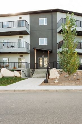 Saskatoon apartment for rent - A modern apartment building with a tree in front.