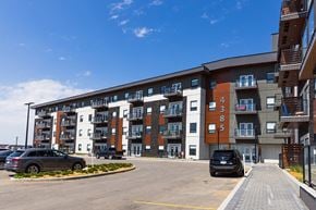Saskatoon townhouse for rent - a large apartment building with cars parked in front of it