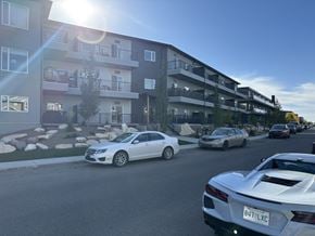 Saskatoon apartment for rent - A white car with the license plate 8U7 LXC is parked on a street.