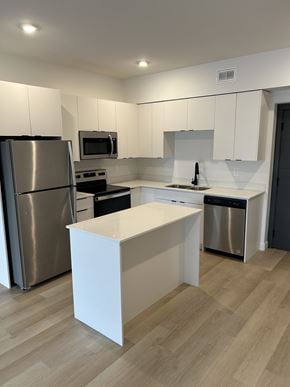 Saskatoon apartment for rent - A modern kitchen with a white island in the middle.