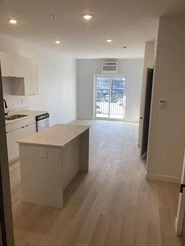 Saskatoon apartment for rent - A kitchen with white cabinets and a white island.
