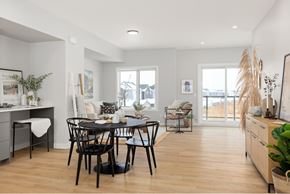 Saskatoon townhouse for rent - A dining room with a table set for two and a view of the backyard.