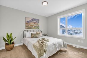 Saskatoon townhouse for rent - A bedroom with a large bed and a painting on the wall.