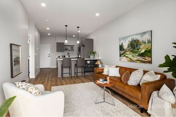 Saskatoon apartment for rent - A living room with a brown couch and a painting on the wall.