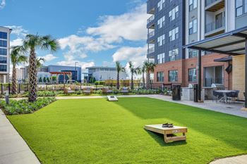 A yard with grass and palm trees in front of a building