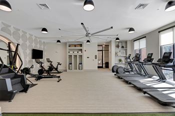 A gym with treadmills and a tv on the wall