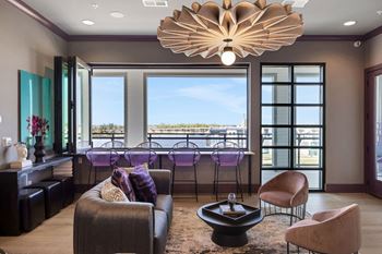 A living room with a bar and a view of the water