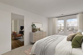 Manassas apartment for rent - a bedroom with a bed and a dresser and a window at The Fields of Manassas