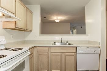 A kitchen with white appliances and wooden cabinets