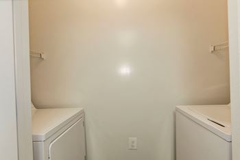 An empty laundry room with a washer and dryer and a sink