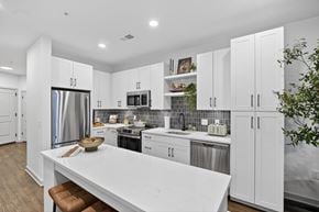 Reston apartment for rent - A modern kitchen with white cabinets and a central island.