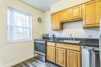 A kitchen with wooden cabinets and a black granite countertop