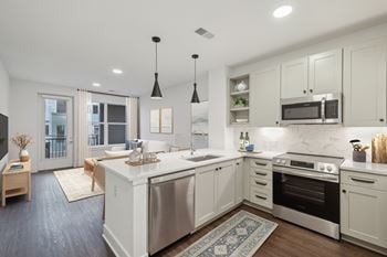 A modern kitchen with a large island and stainless steel appliances.