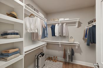 A white closet with clothes and a hat on the shelf.