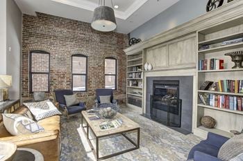 A living room with a brick wall and a fireplace