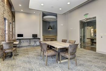 A conference room with a large table and chairs and a glass door