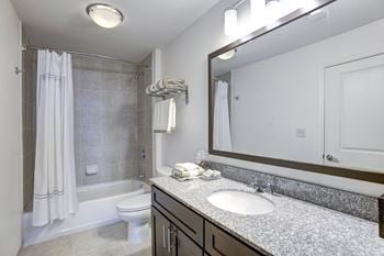 A bathroom with a sink and a shower and a toilet