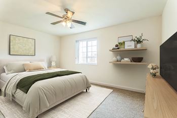 A bedroom with a bed, a ceiling fan, and a window