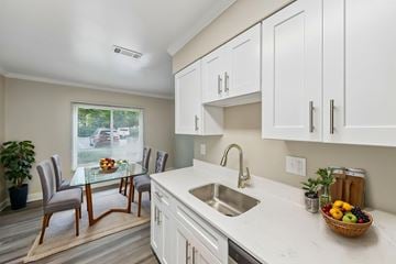 Tysons apartment for rent - A kitchen with white cabinets and a glass table.