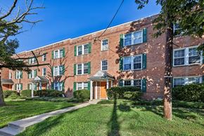 Rockville apartment for rent - A red brick building with green shutters and a yellow door.