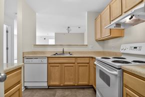 Woodbridge apartment for rent - A kitchen with a white stove and wooden cabinets.