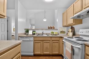 Woodbridge apartment for rent - A kitchen with wooden cabinets and a stove top oven.