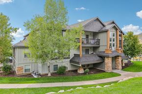 Hideout apartment for rent - A large house with a grey exterior and a balcony.