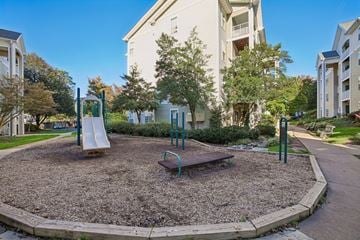 Falls Church apartment for rent - A playground with a slide and a bench in the middle of a gravel area.