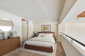 Baltimore apartment for rent - A bedroom with a large bed and a brown dresser.