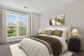 Woodbridge apartment for rent - A bedroom with a large bed and a window with curtains.