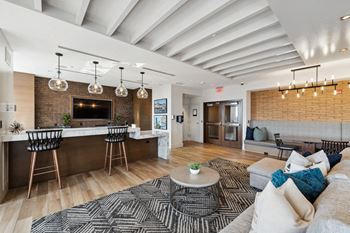 A living room with a couch and a kitchen with a bar