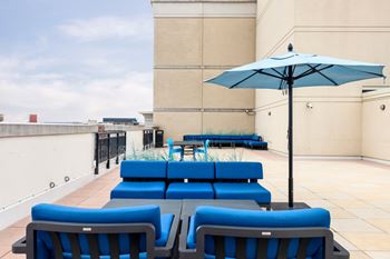 A blue umbrella is on a blue chair.