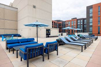 A patio with blue couches and umbrellas.