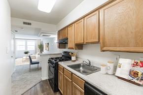 Rockville apartment for rent - A kitchen with wooden cabinets and a black stove top oven at The Fields of Rockville, Rockville, 20850