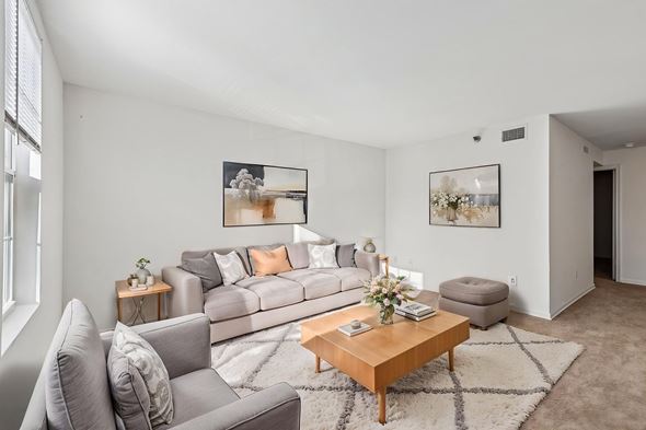Rockville apartment for rent - A living room with a grey couch, a wooden coffee table, and two pictures on the wall.