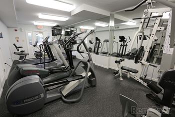 A gym full of exercise equipment in a building