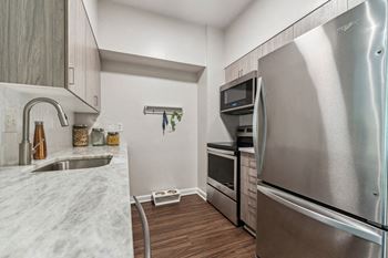 A kitchen with stainless steel appliances and marble counter tops