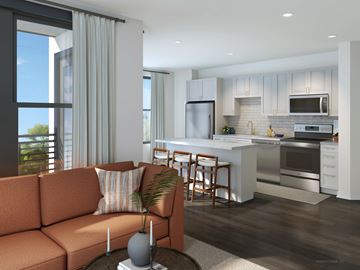 Tampa apartment for rent - A modern kitchen with a bar stool and a sofa.