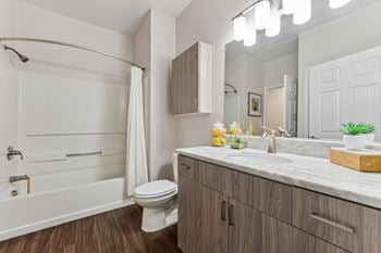 A bathroom with a toilet and a shower and a sink