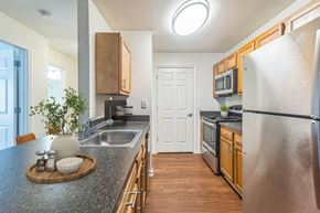 Lorton apartment for rent - a kitchen with stainless steel appliances and granite counter tops at Sanger Place, Virginia, 22079